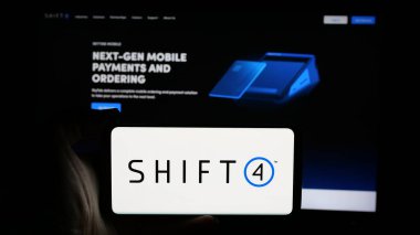 Stuttgart, Almanya - 01-08-2024: ABD 'li finans şirketi Shift4 Payments Inc.' in logosuyla cep telefonu sahibi kişi iş sayfasının önünde ekranda. Telefon ekranına odaklan.