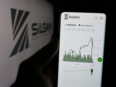 Stuttgart, Almanya - 01-08-2024: ABD 'li ambalaj şirketi Silgan Holding Inc.' in web sayfası ile cep telefonu tutan kişi logonun önünde ekranda. Telefon ekranının merkezine odaklan.