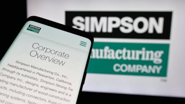 Stuttgart, Almanya - 01-08-2024: Smartphone ve ABD 'li Simpson İmalat Şirketi' nin web sitesi iş logosu önünde ekranda. Telefon ekranının sol üst kısmına odaklan.