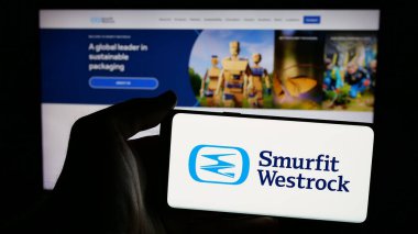 Stuttgart, Almanya - 01-08-2024: Paket şirketi Şirin Westrock 'ın logosunun bulunduğu cep telefonu sahibi kişi iş sayfasının önünde ekranda. Telefon ekranına odaklan.