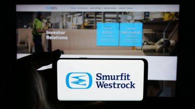 Stuttgart, Almanya - 01-08-2024: Paket şirketi Şirin Westrock 'ın logosunun bulunduğu cep telefonu sahibi kişi iş sayfasının önünde ekranda. Telefon ekranına odaklan.