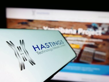 Stuttgart, Germany - 04-02-2023: Smartphone with logo of company Hastings Technology Metals Ltd. on screen in front of business website. Focus on left of phone display. clipart