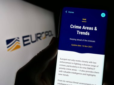 Stuttgart, Almanya - 04-02-2023: AB yasa uygulama dairesi Europol 'ün İnternet sayfası ile akıllı telefonu logo önünde ekranda tutan kişi. Telefon ekranının merkezine odaklan.