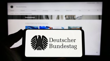 Stuttgart, Almanya - 04-02-2023: Alman federal parlamentosu Bundestag mührü taşıyan kişi web sitesinin önünde ekranda. Telefon ekranına odaklan.