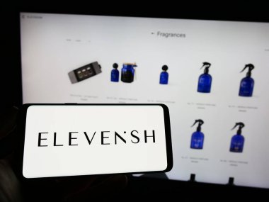 Stuttgart, Almanya - 04-02-2023: Emirati e-ticaret şirketi ELEVENiSH 'in logosunun bulunduğu cep telefonu sahibi kişi iş sayfası önünde ekranda görülüyor. Telefon ekranına odaklan.