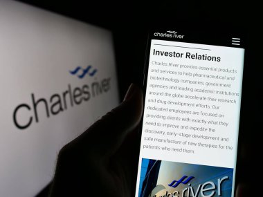 Stuttgart, Almanya - 04-02-2023: Charles River Laboratuvarları International Inc. sitesi ile akıllı telefonu olan kişi ekranda logolu. Telefon ekranının merkezine odaklan.