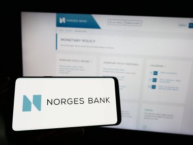 Stuttgart, Almanya - 04-02-2023: Norveç merkez bankası Norges Bank 'ın logosunun bulunduğu cep telefonu web sayfası önünde ekranda. Telefon ekranına odaklan.