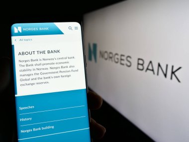 Stuttgart, Almanya - 04-02-2023: Norveç merkez bankası Norges Bank 'ın web sayfası olan akıllı telefon sahibi kişi logonun önünde ekranda. Telefon ekranının merkezine odaklan.
