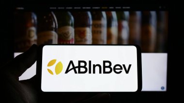 Stuttgart, Almanya - 04-04-2023: Web sitesinin önünde bira üreten firma Anheuser-Busch InBev 'in (AB InBev) logosuna sahip kişi ekranda. Telefon ekranına odaklan.