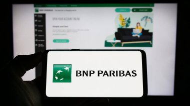Stuttgart, Almanya - 04-04-2023: Fransız bankacılık şirketi BNP Paribas S.A. 'nın logosuna sahip kişi web sitesinin önünde ekranda. Telefon ekranına odaklan.