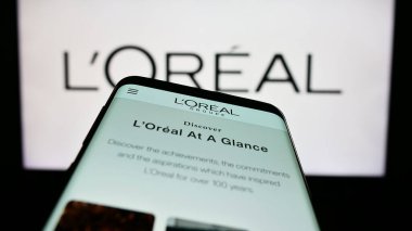Stuttgart, Almanya - 04-04-2023: Fransız kişisel bakım şirketi L 'Oreal S.A.' nın web sayfası ile birlikte ticari logonun önünde. Telefon ekranının sol üst kısmına odaklan.