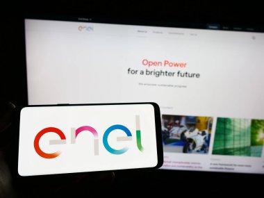 Stuttgart, Almanya - 04-16-2023: İtalyan kamu hizmetleri şirketi Enel S.P.A. 'nın logosunu taşıyan kişi web sitesinin önünde ekranda. Telefon ekranına odaklan.