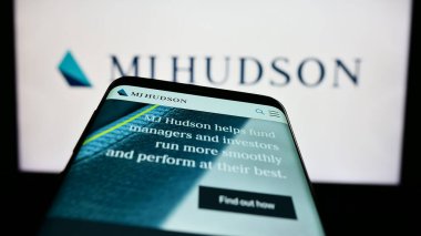 Stuttgart, Almanya - 04-19-2023: İngiliz finans şirketi MJ Hudson Group plc 'in web sitesi olan akıllı telefon iş logosu önünde ekranda. Telefon ekranının sol üst kısmına odaklan.