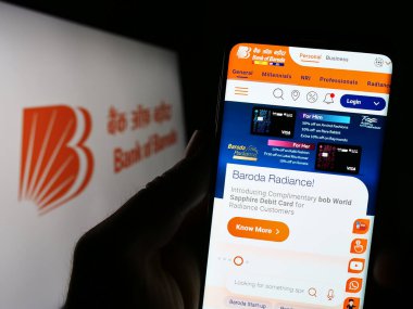 Stuttgart, Almanya - 04-19-2023: Hintli Bank of Baroda Ltd. (BOB) şirketinin web sitesi olan kişi logonun önünde ekranda. Telefon ekranının merkezine odaklan.