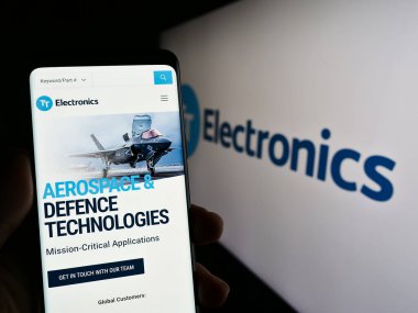 Stuttgart, Almanya - 04-20-2023: İngiliz TT Electronics plc şirketinin web sayfası logonun önünde duran kişi. Telefon ekranının merkezine odaklan.