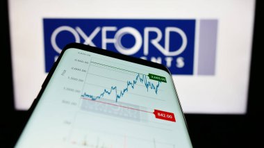 Stuttgart, Almanya - 04-20-2023: İngiliz Oxford Instruments plc şirketinin web sitesi olan cep telefonu iş logosu önünde ekranda. Telefon ekranının sol üst kısmına odaklan.