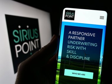 Stuttgart, Almanya - 04-21-2023: Sigorta şirketi SiriusPoint Ltd. 'nin web sitesi ile akıllı telefonu olan kişi logonun önünde ekranda. Telefon ekranının merkezine odaklan.