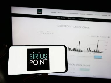 Stuttgart, Almanya - 04-21-2023: Sigorta şirketi SiriusPoint Ltd. 'nin logosu olan cep telefonu sahibi kişi iş sayfasının önünde ekranda. Telefon ekranına odaklan.