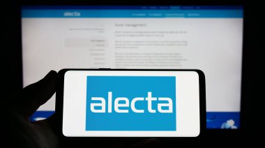 Stuttgart, Almanya - 04-23-2023: İsveç emeklilik fonu logosu olan akıllı telefon sahibi kişi web sitesinin önünde ekranda. Telefon ekranına odaklan.