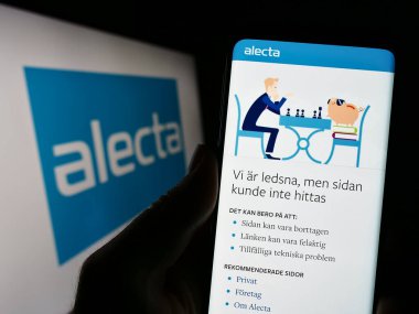 Stuttgart, Almanya - 04-23-2023: İsveç emeklilik fonu Alecta 'nın web sayfası olan cep telefonu sahibi şirket logosu önünde ekranda. Telefon ekranının merkezine odaklan.
