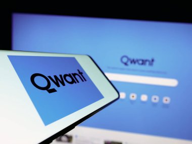 Stuttgart, Almanya - 04-23-2023: Fransız arama motoru şirketi Qwant SAS 'ın logosuna sahip cep telefonu iş sitesinin önünde ekranda. Telefon ekranının merkez soluna odaklan.