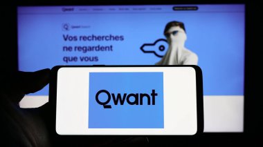 Stuttgart, Almanya - 04-23-2023: Fransız arama motoru şirketi Qwant SAS 'ın logosunun bulunduğu cep telefonu sahibi kişi iş sayfasının önünde ekranda. Telefon ekranına odaklan.