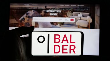 Stuttgart, Almanya - 01-14-2025: İsveçli emlak şirketi Fastighets AB Balder 'ın logosunun bulunduğu cep telefonu web sayfası önünde ekranda. Telefon ekranına odaklan.