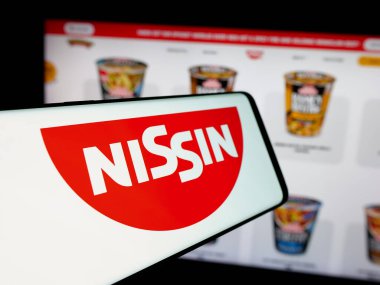Stuttgart, Almanya - 01-14-2025: Japon şirketi Nissin Foods Holding Co. Ltd. nin logolu akıllı telefon web sitesinin önünde ekranda. Telefon ekranının merkez soluna odaklan.
