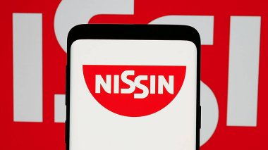 Stuttgart, Germany - 01-14-2025: Mobile phone with logo of Japanese company Nissin Foods Holdings Co. Ltd. on screen. Focus on phone display. clipart