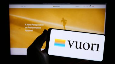 Stuttgart, Almanya - 03-30-2023: İnternet sitesi önünde ekranda ABD 'li giyim şirketi Vuori Inc.' nin logosunu taşıyan akıllı telefon sahibi kişi. Telefon ekranına odaklan.