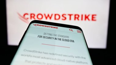 Stuttgart, Almanya - 03-31-2023: Siber güvenlik şirketi CrowdStrike Holding Inc. 'in web sitesiyle birlikte logo önünde cep telefonu. Telefon ekranının sol üst kısmına odaklan.