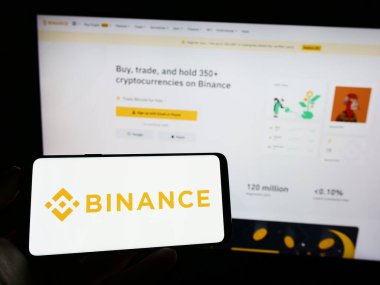 Stuttgart, Almanya - 03-31-2023: Şifreleme firması Binance Holding Ltd. 'nin logosu olan cep telefonu web sayfasının önünde ekranda. Telefon ekranına odaklan.