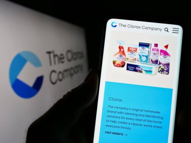 Stuttgart, Germany - 03-31-2023: Person holding cellphone with webpage of US chemicals manufacturer Clorox Company on screen in front of logo. Focus on center of phone display. clipart