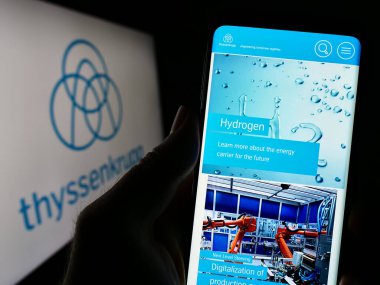 Stuttgart, Almanya - 03-31-2023: Alman holdingi ThyssenKrupp AG 'nin web sitesine sahip kişi logonun önünde ekranda. Telefon ekranının merkezine odaklan.