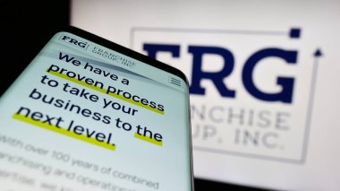 Stuttgart, Almanya - 03-31-2023: İş logosu önünde ABD 'li Franchise Group Inc. (FRG) siteli akıllı telefon. Telefon ekranının sol üst kısmına odaklan.