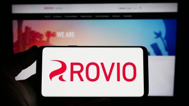 Stuttgart, Almanya - 03-31-2023: İnternet sitesi önünde üzerinde Fin oyun şirketi Rovio Entertainment Oyj 'un logosu bulunan kişi. Telefon ekranına odaklan.