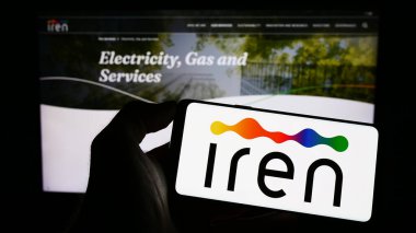 Stuttgart, Almanya - 03-31-2023: İtalyan kamu hizmetleri şirketi Iren SpA 'nın logosunun bulunduğu cep telefonu sahibi kişi iş sayfasının önünde ekranda. Telefon ekranına odaklan.