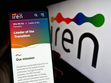 Stuttgart, Almanya - 03-31-2023: İtalyan kamu hizmetleri şirketi Iren S.P.A. 'nın internet sayfası ile akıllı telefonu olan kişi logonun önünde ekranda. Telefon ekranının merkezine odaklan.