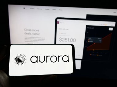 Stuttgart, Almanya - 03-31-2023: Web sayfasının önünde ekranda Amerikalı enerji yazılım şirketi Aurora Solar Inc. 'in logosuyla cep telefonu tutan kişi. Telefon ekranına odaklan.