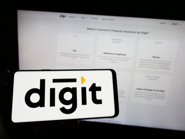 Stuttgart, Almanya - 03-31-2023: Go Digit General Insurance Limited şirketinin logosuna sahip akıllı telefon sahibi kişi web sitesinin önünde ekranda. Telefon ekranına odaklan.