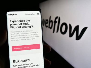 Stuttgart, Almanya - 03-31-2023: ABD web geliştirme yazılım şirketi Webflow Inc. 'in web sayfası ile akıllı telefon sahibi kişi logo ile ekranda. Telefon ekranının merkezine odaklan.