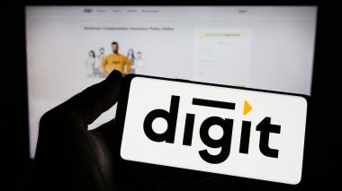 Stuttgart, Almanya - 03-31-2023: Go Digit General Insurance Limited şirketinin logosuna sahip cep telefonu sahibi kişi web sayfasının önünde ekranda görülüyor. Telefon ekranına odaklan.