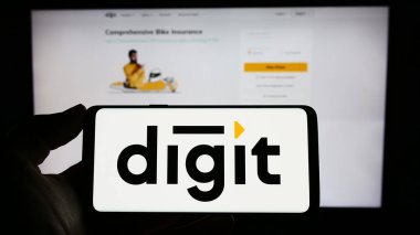 Stuttgart, Almanya - 03-31-2023: Go Digit General Insurance Limited şirketinin logosuna sahip cep telefonu sahibi kişi iş sayfasının önünde ekranda görülüyor. Telefon ekranına odaklan.