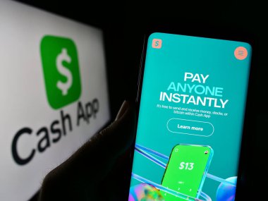 Stuttgart, Almanya - 04-01-2023: ABD 'li fintech şirketi Cash App Investing LLC' nin web sayfası ile akıllı telefon sahibi kişi logo önünde ekranda. Telefon ekranının merkezine odaklan.
