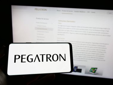 Stuttgart, Almanya - 04-01-2023: Tayvanlı Pegatron Corporation şirketinin logosunun bulunduğu cep telefonu sahibi kişi iş sayfasının önünde ekranda. Telefon ekranına odaklan.