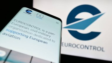 Stuttgart, Almanya - 04-01-2023: Hava trafiği yönetim kuruluşu Eurocontrol 'un web sitesiyle birlikte cep telefonu logonun önünde ekranda. Telefon ekranının sol üst kısmına odaklan.