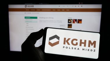Stuttgart, Almanya - 04-01-2023: Polonyalı maden şirketi KGHM Polska Miedz SA 'nın logosuyla cep telefonu sahibi olan kişi iş sayfası önünde ekranda görülüyor. Telefon ekranına odaklan.
