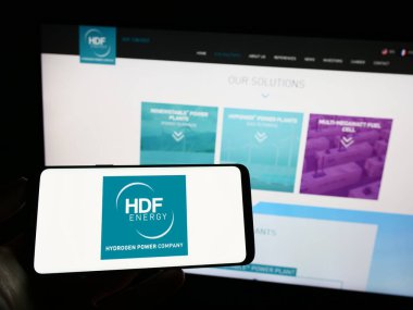 Stuttgart, Almanya - 04-01-2023: Fransız hidrojen şirketi HDF Energy 'nin logosunun bulunduğu cep telefonu sahibi kişi iş sayfasının önünde ekranda. Telefon ekranına odaklan.