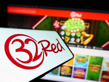 Stuttgart, Almanya - 04-01-2023: İnternet kumarhane şirketi 32Red Limited 'in logosuna sahip cep telefonu iş sitesinin önünde ekranda. Telefon ekranının merkez soluna odaklan.