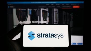 Stuttgart, Almanya - 04-01-2023: İnternet sitesinin önünde ekranda 3D baskı şirketi Stratasys Ltd. 'nin logosuna sahip akıllı telefonu tutan kişi. Telefon ekranına odaklan.